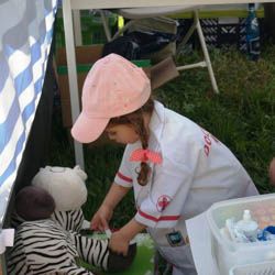 Miniatura: Mała dziewczynka-pediatra nakleja plaster na nogę chorej zebry-pluszaka podczas festynu na Siekierkach w Warszawie
